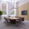 Large room with conference table and chairs with tv and plants with large windows