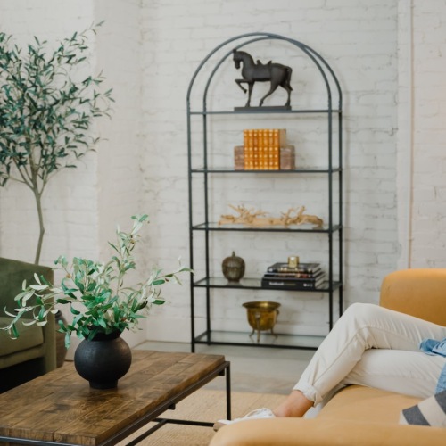 Wide open living areas flooded with natural light man sitting on couch drinking