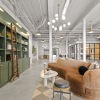 Room with concrete floors, lounge seating, a large green bookshelf 
