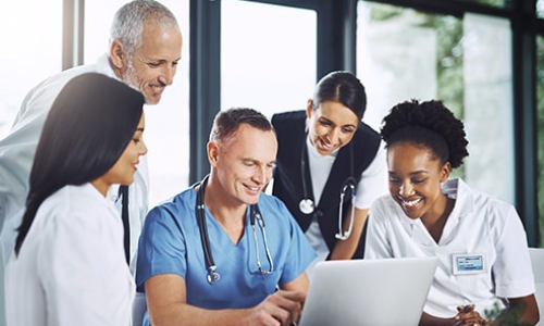 medical professionals around a laptop