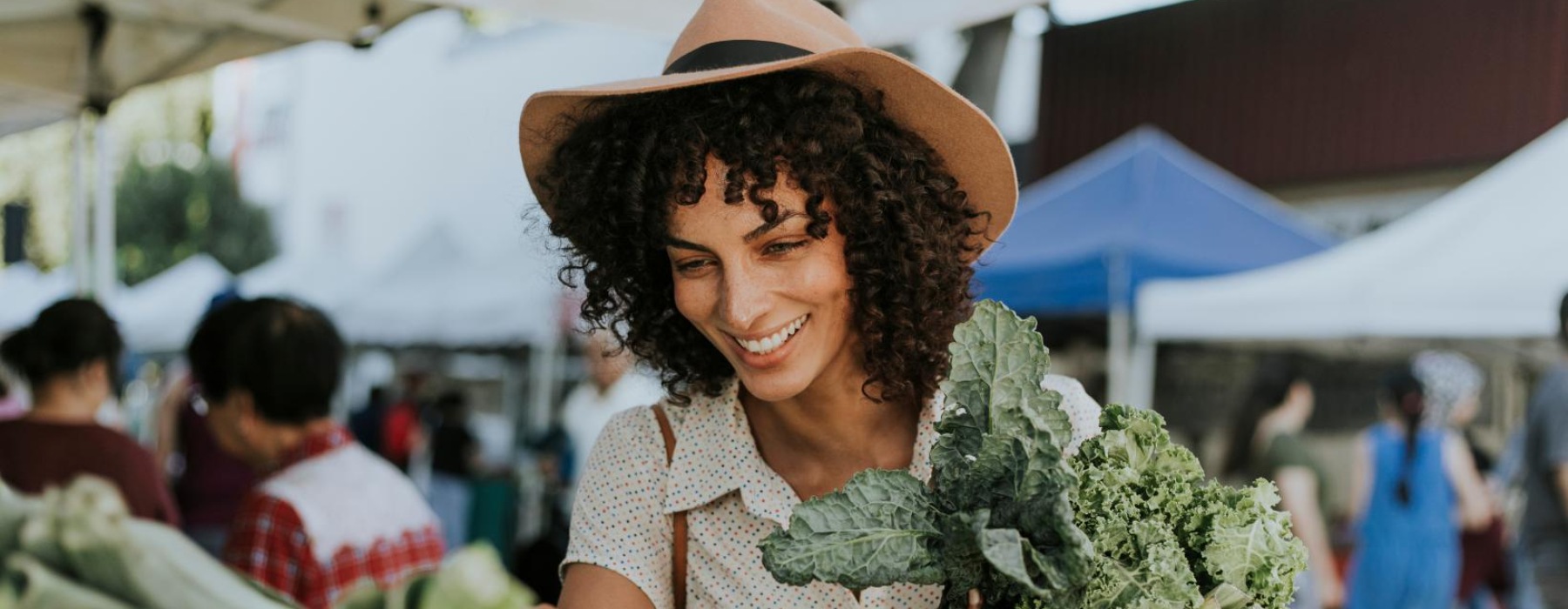 a woman holding a bunch of vegetables